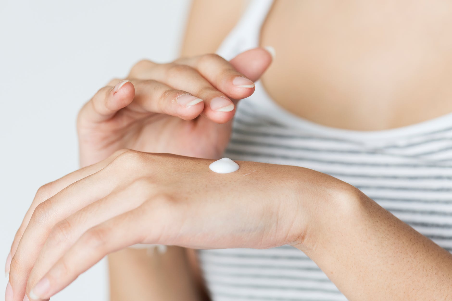 photo of woman with lotion on hand