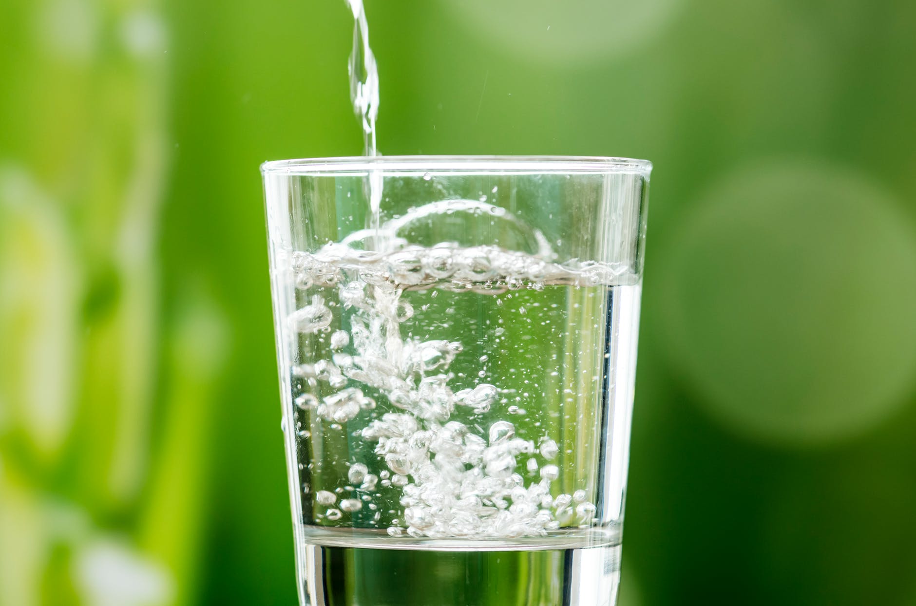 water pouring in clear drinking glass